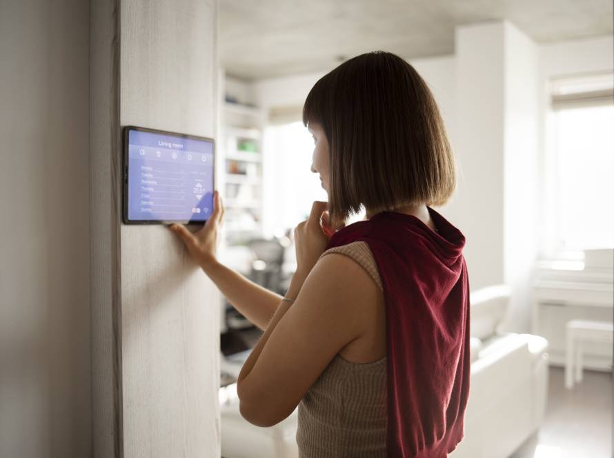žena využívajúca dotykovú obrazovku na nastavenie zariadení smart home